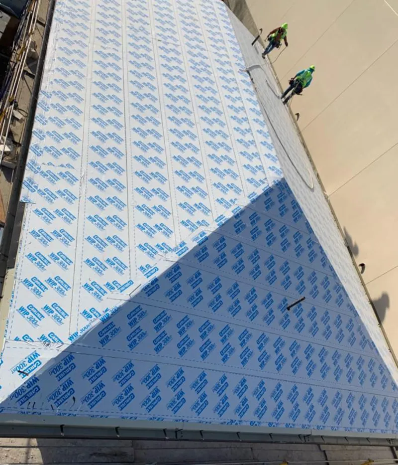 Professional roofers installing underlayment on a metal roof in Revere